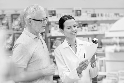 senior man and a pharmacist looking at a prescription