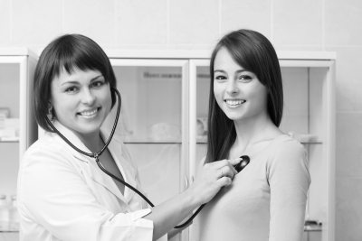 pharmacist checking woman's blood pressure